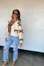 Load image into Gallery viewer, The trendiest cardigan of the season and sure to be a HIT! These crop knit, open front cardigans featuring knit camo and cheetah bows with a slight bubble sleeve arm.