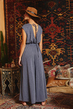 Load image into Gallery viewer, Effortlessly chic and endlessly comfortable, this open front jumpsuit is your go-to for laid-back elegance. Featuring a flattering elastic waistband and breezy wide legs, it drapes beautifully for a relaxed silhouette. The deep open front adds a touch of allure, while the v-neckline at the back with an adjustable drawstring tie brings an unexpected twist. Finished with side pockets for everyday ease, this jumpsuit is perfect for everything from beach days to brunch dates.