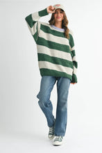 Load image into Gallery viewer, The sweater you’ll live in all season long. This oversized knit features bold forest green stripes and a contrasting lavender neckline for a playful twist. Easy to throw on with jeans or a maxi skirt- cozy, carefree, and totally essential.
